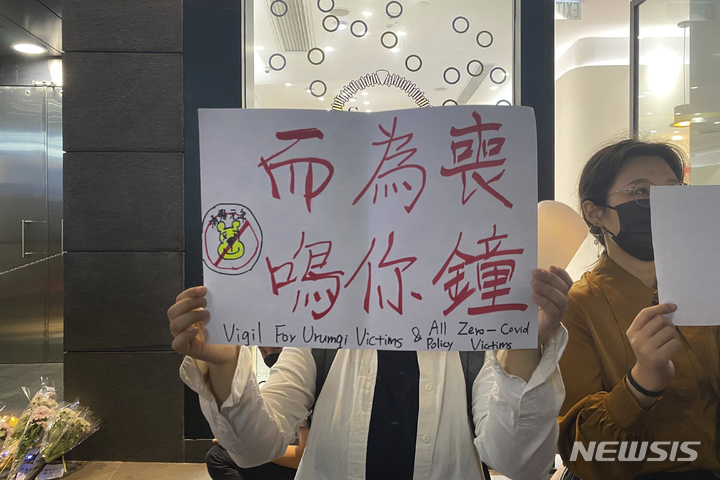 [홍콩=AP/뉴시스]한 시위자가 28일 홍콩 중구에서 최근 우루무치 화재의 희생자들을 애도하는 피켓을 들고 있다. 중국 본토의 몇몇 도시에서 집권 공산당을 반대하고 시진핑 주석의 사임을 요구하는 시위가 열리자, 홍콩 학생들은 중국의 코로나 바이러스 통제에 반대하는 시위를 갖고 "독재 반대"를 외쳤다. 2022.11.29.