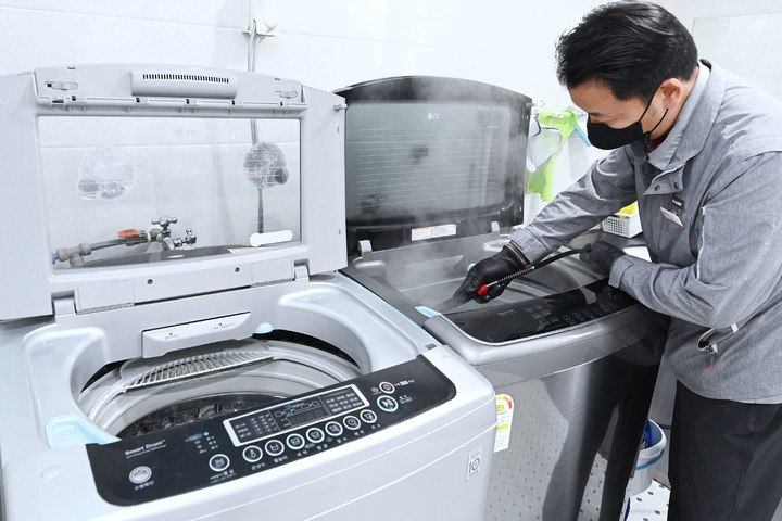 [서울=뉴시스] LG전자 직원이 사회복지시설에서 세탁통에 스팀을 분사하는 통살균 서비스를 진행하고 있다. (사진=LG전자) 2022.12.04. photo@newsis.com  *재판매 및 DB 금지