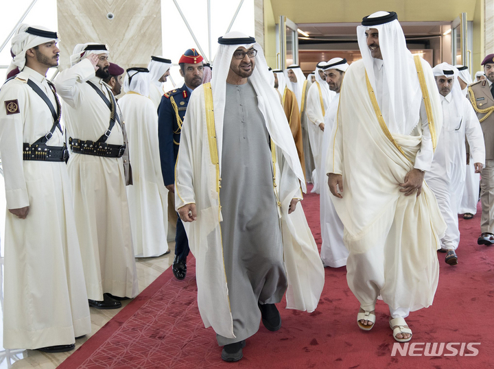 [AP/뉴시스] 카타르 당국이 배포한 사진으로 5일 카타르의 셰이크 타밈 국왕(오른쪽)이 UAE 대통령인 셰이크 모하메드 빈자예드 아부다비 토후를 도하 하마드 공항에서 영접 환영하고 있다