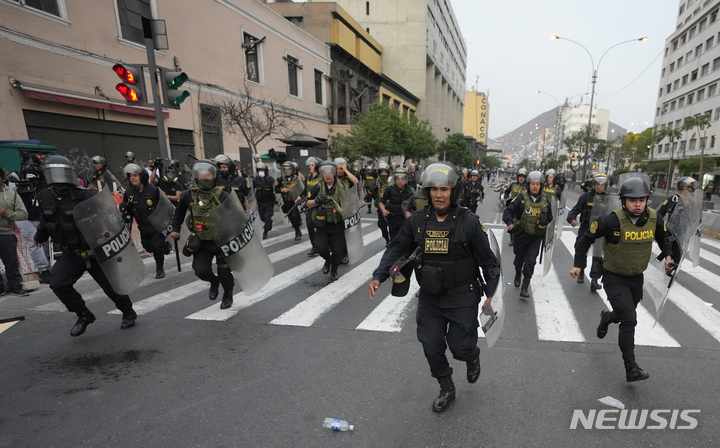 [리마=AP/뉴시스] 페루 경찰이 8일(현지시간) 리마에서 '탄핵 반대'를 외치는 시위대를 진압하기 위해 돌진하고 있다. 페루 검찰은 카스티요 전 대통령이 의회를 해산하려 하는 등 쿠데타를 시도했다며 반란과 음모 혐의로 구금하고 수사한다고 밝혔다. 2022.12.09.