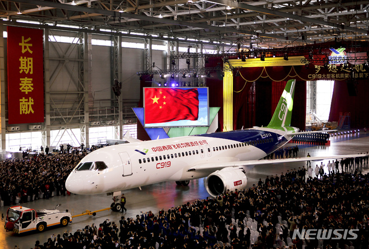 [상하이=AP/뉴시스]진ㄴ 2015년 11월2일 중국 상하이 푸둥(浦東) 국제공항 인근에서 중국상용항공기(COMAC)가 생산한 C919 장거리 여객기가 격납고에서 모습을 드러내고 있다. 중국 둥펑(東方)항공이 9일 중국 항공사들 가운데 처음으로 중국 보잉 및 에어버스와 경쟁하기 위해 설립된 국영 제조업체 중국상용항공기(COMAC)가 생산한 C919 장거리 제트 여객기를 인도받았다고 중국 국영 TV가 보도했다. 2022.12.9
