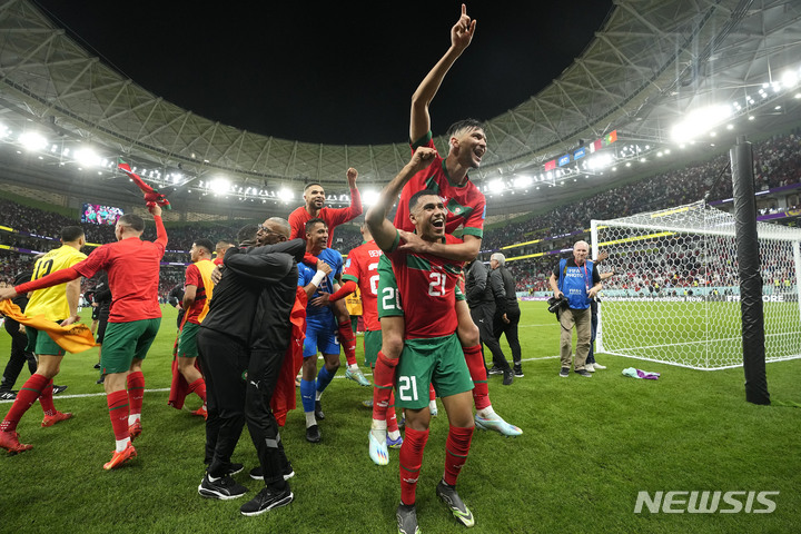 [도하=AP/뉴시스] 모로코 선수들이 11일(한국시간) 카타르 도하의 알 투마마 스타디움에서 열린 포르투갈과 2022 FIFA 카타르 월드컵 8강전에서 1-0으로 이기고 아프리카 첫 4강 진출이라는 위업을 달성한 뒤 기쁨을 나누고 있다. 2022.12.11.