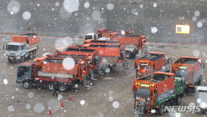 [서울=뉴시스] 권창회 기자 = 눈이 내리는 13일 오후 서울 송파구 제설전진기지에서 제설차량이 제설제를 싣기 위해 대기하고 있다. 기상청은 내일까지 중부지방을 중심으로 최대 10cm의 많은 눈이 내린 후 강력한 한파가 온다고 예보했다. 2022.12.13. kch0523@newsis.com