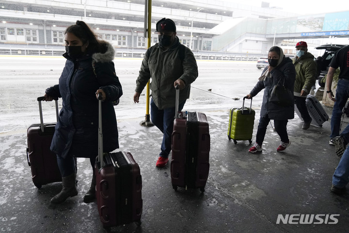 [시카고 = AP/뉴시스] 눈이 얼어붙은 시카고 오헤어 국제공항의 터미널을 22일 조심스럽게 통과하는 탑승객들. 
