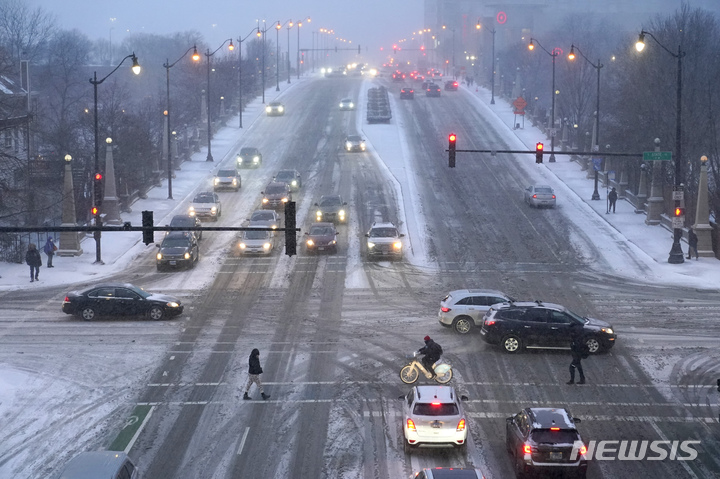 [시카고= AP/뉴시스] 폭설과 강풍으로 미끄러운 시카고의 도로에서 22일(현지시간) 차량들이 거북이 걸음을 하고 있다. 눈폭풍 예고가 내려진 22일 대부분의 학교와 어린이집, 많은 시설들이 휴업에 들어갔다. 