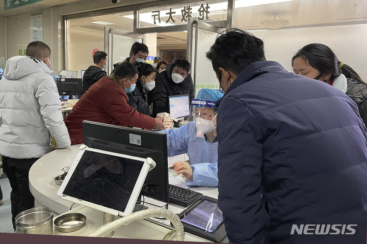 [허베이=AP/뉴시스]지난 22일 중국 허베이성 바저우에 있는 랑팡 4호 병원 응급실에 방문객들이 직원에게 말하고 있다. 2022.12.25