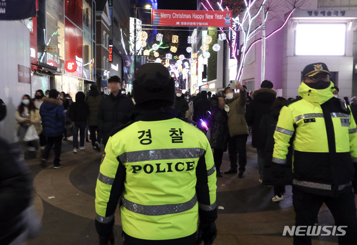 [서울=뉴시스] 최진석 기자 = 지난해 크리스마스 이브 서울 중구 명동거리에서 경찰이 질서 유지를 위해 시민들의 동선을 살펴보고 있다. 2022.12.24. myjs@newsis.com