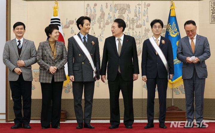 [서울=뉴시스] 홍효식 기자 = 윤석열 대통령이 27일 서울 용산 대통령실 청사에서 '오징어게임'으로 미국 에미상 감독상을 받은 황동혁 감독과 남우주연상을 받은 배우 이정재에게 금관문화훈장을 수여한 뒤 기념촬영하고 있다. (대통령실통신사진기자단) 2022.12.27. yesphoto@newsis.com