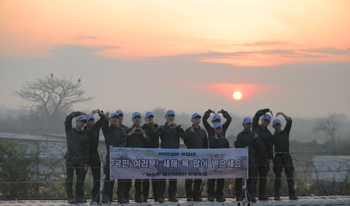 [서울=뉴시스] 1일 한빛부대 장병들이 일출 배경으로 새해인사를 하고 있다. (사진=합참) 2023.01.01. photo@newsis.com *재판매 및 DB 금지