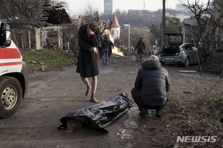 [키이우=AP/뉴시스] 지난해 12월 우크라이나 수도 키이우에서 러시아의 공격으로 사망한 아내의 시신 옆에서 한 남자가 비통해하고 있다. 2023.03.22.