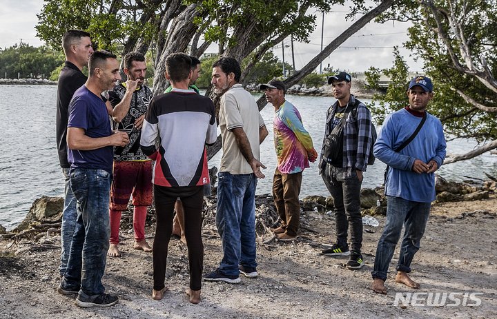 [덕키(플로리다)=AP/뉴시스] 쿠바 마탄자스에서 온 쿠바 이민자들이 2일(현지시간) 플로리다주 미들키스 섬 덕키에 도착해 미국 국경순찰대 요원들이 데리러 오기를 기다리고 있다. 이들은 두 척의 보트로 이곳에 상륙했다. 2022.1.22