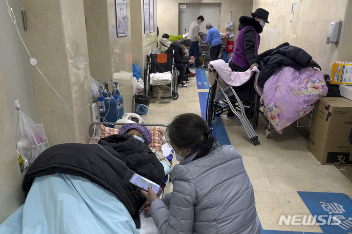 [베이징=AP/뉴시스] 3일 중국 베이징의 한 병원 응급병동 복도에 링거를 꽂은 노인들이 보호자의 보살핌을 받으며 누워 있다. 유럽연합(EU)은 코로나19 방역 완화로 확진자가 급증한 중국을 돕기 위해 무료로 백신을 제공하기로 했다. 2023.01.03.