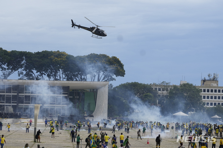 [브라질리아=AP/뉴시스]하이르 보우소나루 전 브라질 대통령을 지지하는 시위대들이 8일(현지시간) 수도 브라질리아의 대통령 집무실을 점거, 경찰과 대치하고 있다. 2023.01.09.