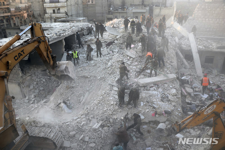 [알레포( 시리아)=AP/뉴시스] 시리아 알레포 건물붕괴 현장에서 22일(현지시간) 구조대와 주민들이 5층 건물 잔해 속에 묻힌 생존자들을 수색하고 있다. ( 쿠르드자치구의 하와르 뉴스 통신 제공 사진 ) 