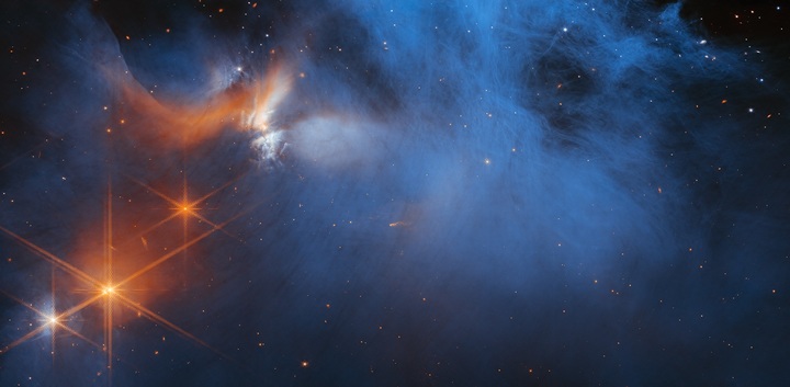 나사는 제임스웹 우주망원경을 사용하는 국제 천문학자 팀이 지구에서 630광년 떨어진 '카멜레온Ⅰ' 분자운에서 관측된 가장 깊고 차가운 얼음을 심층 분석하는 데 성공했다고 밝혔다. 차갑고 희미한 푸른색 분자운(가운데)이 젊은 주황색 원시별 'Ced 110 IRS 4(왼쪽 상단)'의 빛에 의해 적외선으로 관측되고 있다. 분자운 뒤 수많은 별들에서 뿜어져나오는 빛들은 이를 흡수하는 분자운 속 얼음을 감지하는 데 활용된다. (사진=나사) *재판매 및 DB 금지