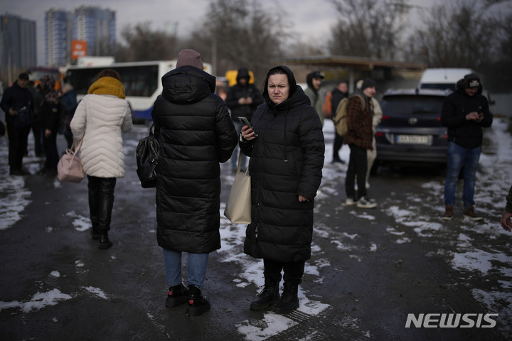 [키이우=AP/뉴시스]26일(현지시간) 러시아의 미사일 공습 후 우크라이나 키이우에서 시민들이 경찰로 인해 차단된 거리에서 기다리고 있다. 2023.01.27.