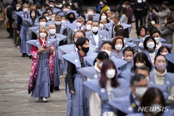 [도쿄=AP/뉴시스]지난 3일 일본 도쿄 조죠지 사원에서 입춘을 앞두고 연례 '마메마키' 행사가 열려 참가자들이 행진하고 있다. 행사에 참여한 시민들이 야외에서도 마스크를 착용한 모습이 눈에 띈다. 2023.02.09.