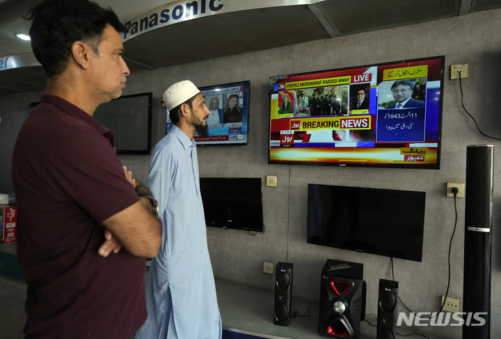 [카라치( 파키스탄)= AP/뉴시스] TV뉴스로 무샤라프의 사망 소식을 시청하고 있는 파키스탄 국민들. 