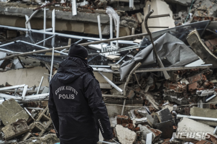 [가지안테프=AP/뉴시스] 6일(현지시간) 튀르키예 가지안테프에서 한 경찰관이 구조대와 함께 지진으로 파괴된 건물을 수색하고 있다. 이날 새벽 발생한 지진과 여진으로 튀르키예와 시리아에서의 사망자 숫자가 늘어가고 있다. 2023.02.07.