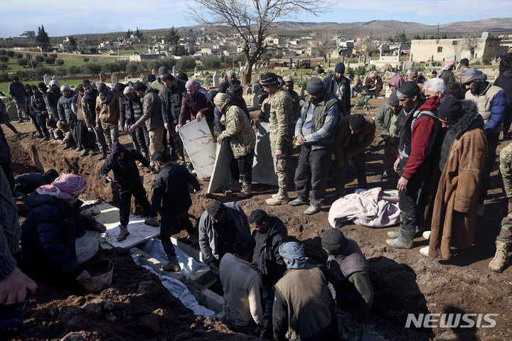 [진데리스=AP/뉴시스] 7일(현지시간) 잔해 속에서 신생아가 발견된 시리아 진데리스에서 주민들과 유가족들이 희생자 시신을 매장하고 있다. 튀르키예와 시리아를 강타한 지진으로 지금까지 사망자가 1만 2000명을 넘은 것으로 보도되었다. 