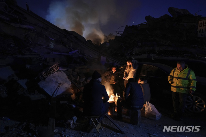 [안타키아=AP/뉴시스] 8일(현지시간) 튀르키예 남동부 안타키아 지진 피해 현장에서 시민이 모닥불로 몸을 녹이고 있다. 2023.02.09.