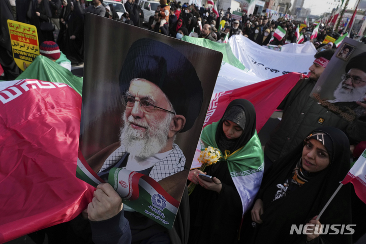 [테헤란(이란) = AP/뉴시스] 2월 11일 이란 혁명 기념일 44주년 행진에 참가한 테헤란 시내 군중이 이란 최고지도자 알리 하메이니의 초상화를 들고 행진하고 있다.  이란 국내 반정부 시위와 서방의 제재에도 불구하고 이 날 기념행진은 전국적으로 거행되었다.