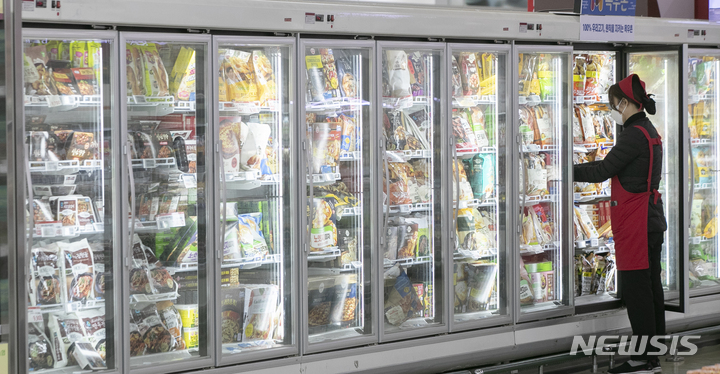 [서울=뉴시스] 김근수 기자 = 13일 서울 시내의 한 대형마트 내 식품매장 도어형 냉장고에서 한 직원이 물건을 정리하고 있다. 한국전력공사와 대한설비공학회에 따르면 식품 매장의 개방형 냉장고를 문이 설치된 냉장고(도어형 냉장고)로 교체하면 전력 사용량이 50% 감소한다고 밝혔다. 2023.02.13. ks@newsis.com