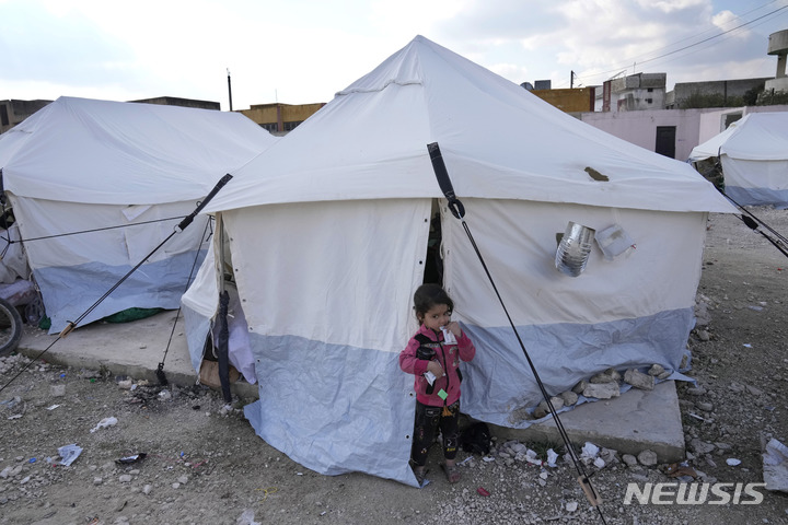 [킬리=AP/뉴시스] 지난 12일(현지시간) 시리아 킬리에 마련된 이재민 대피소 텐트 밖에서 지진으로 가족을 잃은 한 아이가 과자를 먹고 있다. 이번 강진으로 시리아의 사망자 숫자는 약 5800명으로 알려졌다. 2023.02.14. 
