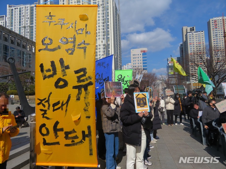 [부산=뉴시스] 이동민 기자 = 21일 오후 부산시청 앞 광장에서 열린 '부산고리2호기 수명연장·핵폐기장 반대 범시민운동본부' 발족 기념 집회에서 환경운동가가 '후쿠시마 원전수 방류 절대 안돼'라고 적힌 시위 깃발을 들고 서 있다. 2023.02.21. eastsky@newsis.com