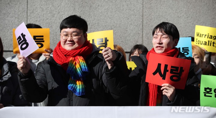 [서울=뉴시스] 김선웅 기자 = 동성부부 소성욱 씨와 김용민 씨가 지난해 2월21일 서울 서초구 서울고등법원에서 열린 국민건강보험공단 상대 보험료 부과 취소 처분 소송 항소심에서 원고 승소 후 입장을 말하며 기뻐하고 있다. 서울고등법원은 소성욱 씨가 건보공단을 상대로 낸 소송의 항소심에서 1심을 뒤집고 동성부부의 건보 피부양자 자격을 인정하며 원고 승소를 판결했다. 2023.02.21. mangusta@newsis.com