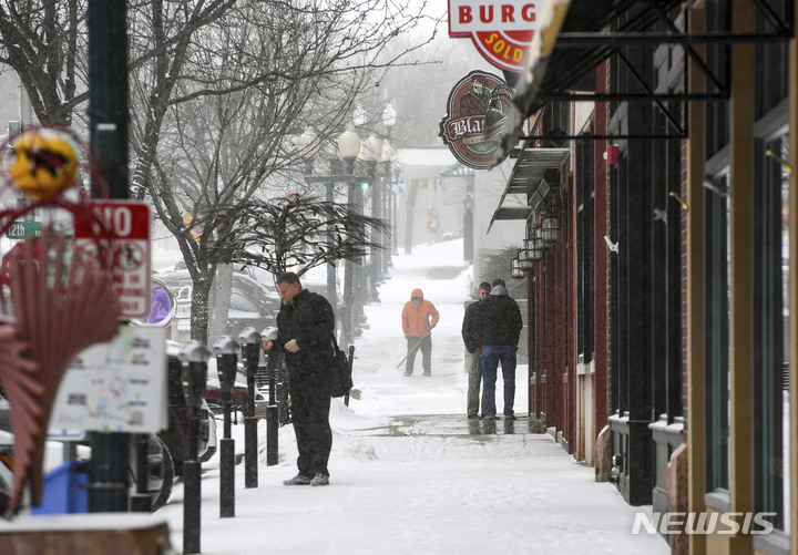 [수폴스=AP/뉴시스] 21일(현지시간) 보행자들이 사우스타코타 수폴스에서 눈 폭풍을 앞두고 도로에 서 있다. 2023.02.22.