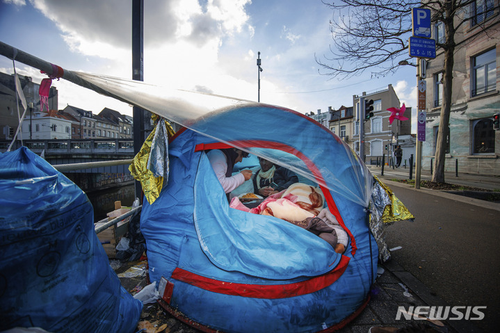 [AP/뉴시스] 벨기에 브뤼셀의 난민신청 센터 앞에서 1월 임시 천막 캠프생활을 하고 있는 망명시도자들이 음식을 나눠먹고 있다