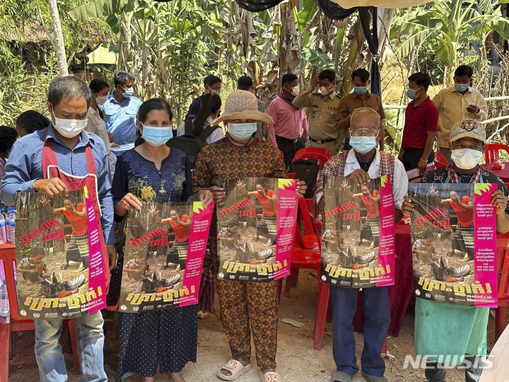 [프레이벵=AP/뉴시스] 캄보디아 보건부가 공개한 사진에 23일(현지시간) 캄보디아 프레이벵 주민들이 H5N1형 조류인플루엔자(AI)에 대한 인식 고취를 위한 포스터를 들고 있다. 캄보디아에서 11세 소녀가 H5N1형 AI에 감염돼 사망하고 포유류에까지 확산하면서 우려가 커지고 있다. 2023.02.23.