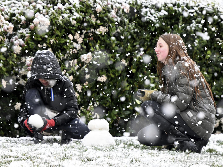 [캘리포니아=AP/뉴시스] 브로디 미엘케(10)와 그의 누나 브래일린(12)이 폰타나에 1,700피트의 눈이 내리는 가운데 25일(현지시간) 함께 눈사람을 만들고 있다. 2023.02.27.