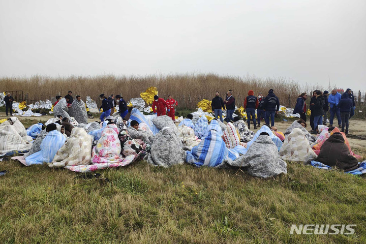 [쿠트로=AP/뉴시스] 26일(현지시간) 이탈리아 칼라브리아주 해안 부근에서 난민을 태운 선박이 침몰한 가운데 현장에서 구조된 난민들이 담요를 덮고 앉아 있다. 2023.02.27.