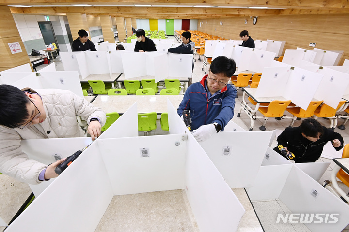 [수원=뉴시스] 김종택 기자 = 27일 경기도 수원시 삼일공업고등학교에서 교직원들이 코로나19 발생 후 의무적으로 설치했던 급식실 칸막이를 철거하고 있다. 오는 3월 시작되는 2023학년도 새 학기부터 마스크 착용과 발열검사 등도 폐지된다. 2023.02.27. jtk@newsis.com