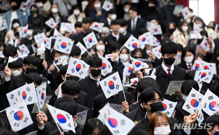 [수원=뉴시스] 김종택 기자 = 1일 경기도 수원시 삼일공업고등학교에서 열린 입학식 및 104주년 3·1절 기념식에서 신입생들이 태극기를 흔들며 삼일절 노래를 제창하고 있다. 2023.03.01. jtk@newsis.com