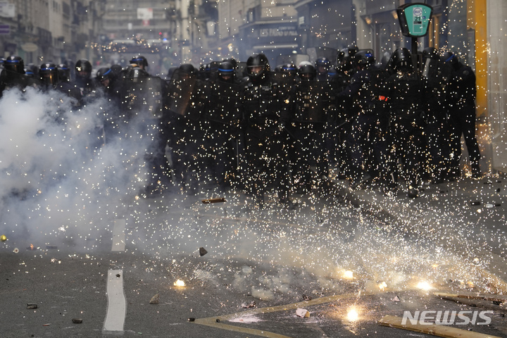 [파리=AP/뉴시스] 폭동 진압 경찰이 7일(현지시간) 프랑스 파리에서 수류탄이 터지는 동안 대열을 구성하고 있다. 2023.03.08.