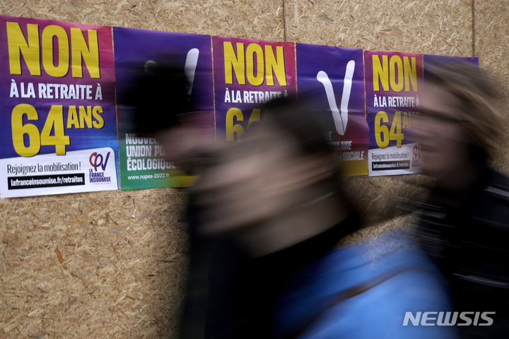 [파리=AP/뉴시스] 7일(현지시간) 프랑스 파리에서 행인들이 퇴직 연령을 62세에서 64세로 높이는 정부의 연금 개혁 반대 포스터를 지나고 있다. 2023.03.08.