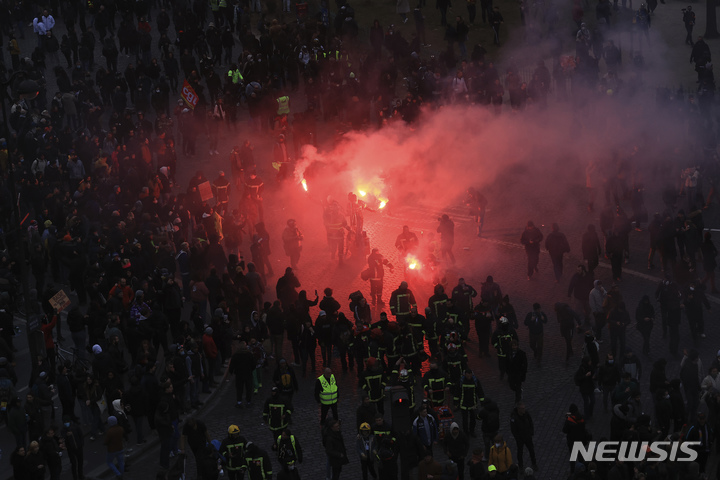 [파리=AP/뉴시스]7일(현지시간) 프랑스 파리에서 정부의 연금 개혁에 반대하는 시위대가 조명탄을 사용하고 있다. 2023.03.08.