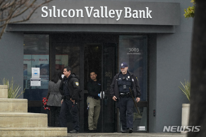 [산타클라라=AP/뉴시스] 경찰관들이 10일(현지시간) 캘리포니아 산타클라라 SVB 출구 앞에 서 있다. 스타트업 기관 자금을 담당하는 실리콘밸리 파이낸셜 그룹이 파산하면서 현금을 조달함에 따라 주가는 60%이상 폭락했다. 분석가들은 실리콘밸리 은행이 특수한 상황에 처해있지만 광범위한 은행 위기로 이어질 수 있다고 우려하고 있다. SVB의 주식은 10일(현지시간) 오전 거래가 중단됐다. 2023.03.13.