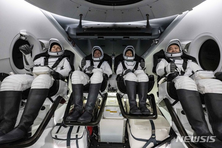 [AP/뉴시스] 인듀어런스 캡슐에 타고 무사귀환 비행사 4명이 걸프만 서해안에서 대개하고 있던 캡슐 수거 선박에 그대로 옮겨진 뒤 환한 미소를 짓고 있다. 왼쪽부터 러시아 여성 비행사, 나사 남녀 비행사 및 일본 비행사. 