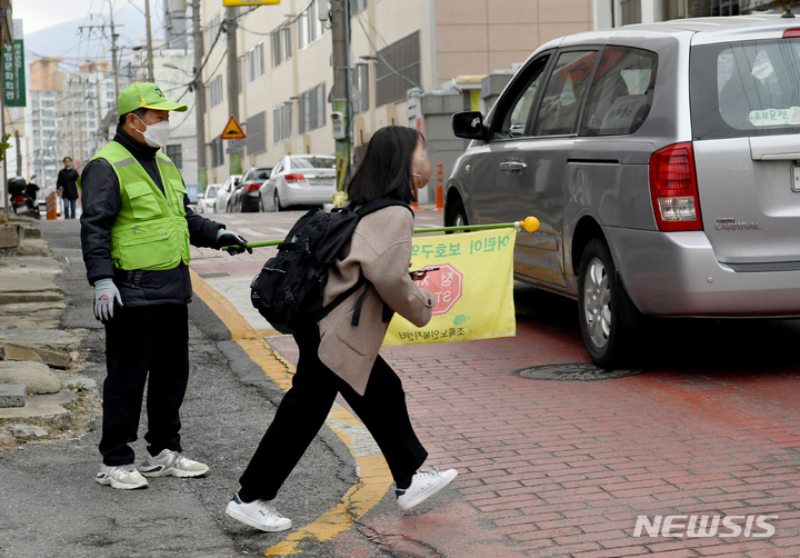 [광주=뉴시스] 김혜인 기자 = 9일 오전 광주 남구 봉선동 한 초등학교 어린이보호구역에서 학생이 길을 건너고 있다. 2023.03.09. hyein0342@newsis.com