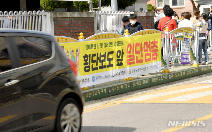 [광주=뉴시스] 김혜인 기자 = 8일 오전 광주 서구 한 초등학교 앞에 '횡단보도 앞 일시정지' 현수막이 붙어있다. 2023.03.08. hyein0342@newsis.com