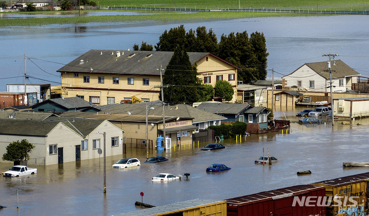 [몬터레이카운티=AP/뉴시스] 13일(현지시간) 미 캘리포니아주 몬터레이 카운티 파하로 커뮤니티의 주택과 차량이 홍수에 잠겨 있다. 관계 당국은 이번 주 또다시 '대기천'(atmospheric rivers) 현상이 발생할 것으로 보인다며 폭우와 홍수에 대비할 것을 강조했다. 2023.03.14.