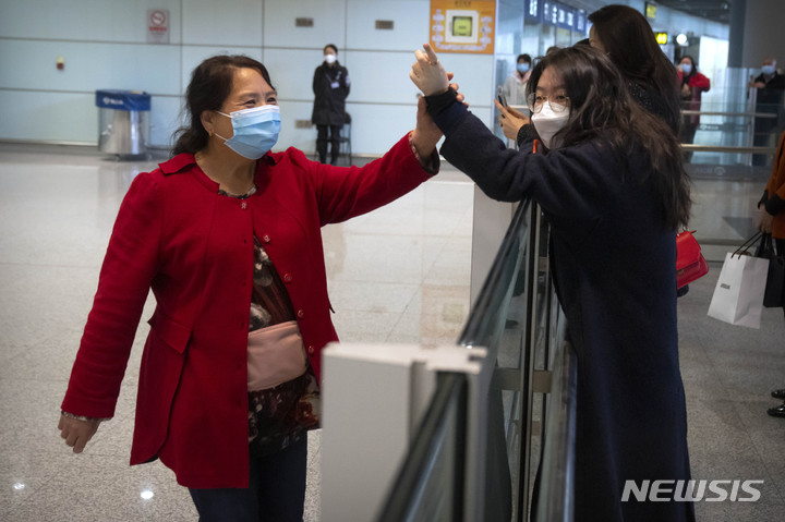 [베이징=AP/뉴시스] 중국이 자국을 방문하는 외국인의 비자 발급 비용을 현행 기준의 75%로 인하한다. 사진은 지난 3월 15일 중국 베이징 국제공항 국제선 입국장을 통해 나온 한 여행객(왼쪽)이 마중 나온 사람과 인사를 나누는 모습. 2023.12.08 