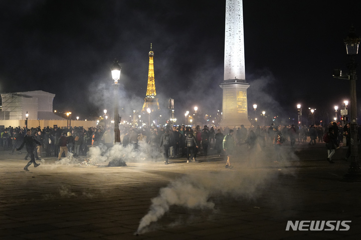 [파리=AP/뉴시스] 시위대가 16일(현지시간) 프랑스 파리에서 최루탄 가스 속에 서 있다. 마크롱 프랑스 대통령은 정년을 64세로 연장하는 연금 개혁안을 하원 표결을 거치지 않고 바로 입법 할 수 있는 헌법 조항을 사용했다. 2023.03.17.