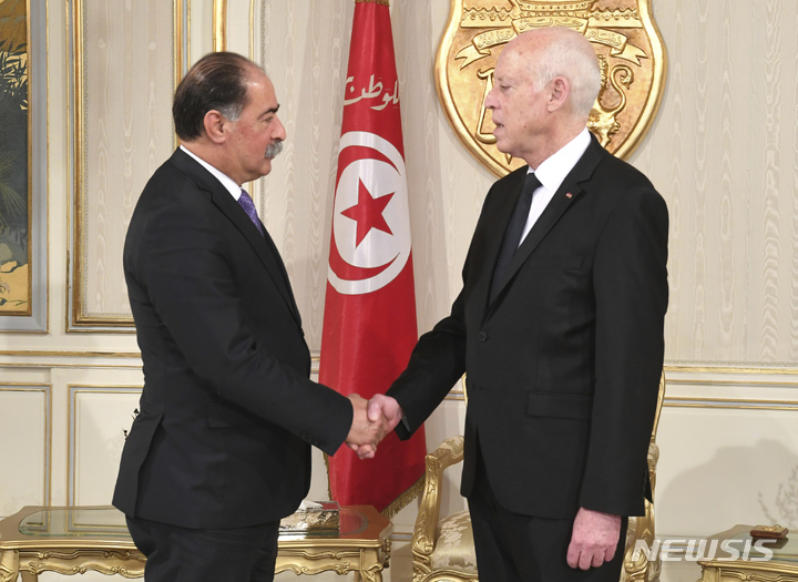 [ 튀니스( 튀니지)= AP/뉴시스]카이스 사예드 튀니지 대통령이 2023년 3월18일 신임 튀니지 내무장관 카멜 페키(왼쪽)의 임명식을 마치고 악수하고 있다.  