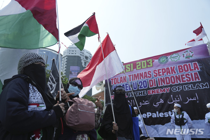 [자카르타=AP/뉴시스] 무슬림 시위자들이 20일(한국시간) 인도네시아 자카르타에서 팔레스타인 깃발을 흔들며 이스라엘의 FIFA U-20 월드컵 참가 금지를 요구하고 있다. 2023.03.20.