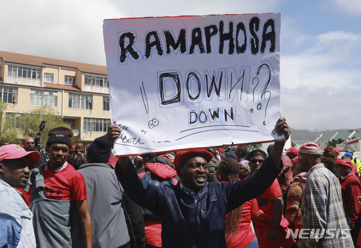 [케이프타운(남아공)=AP/뉴시스]남아공 케이프타운에서 20일 경제자유투사당(EFF)이 촉구한 "국가 폐쇄" 시위에 참여한 시위대가 시릴 라마포사 대통령 퇴진을 요구하는 플래카드를 들고 시위를 벌이고 있다. 경찰은 공공 폭력 등의 혐의로 최소 87명을 체포했다. 2023.3.20